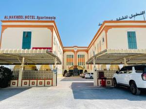 un coche blanco estacionado frente a un edificio en Al Nakheel Hotel Apartments, en Ras al Khaimah