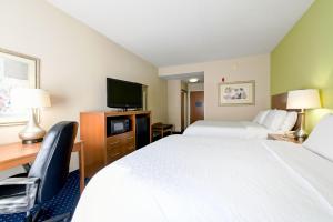 ein Hotelzimmer mit 2 Betten, einem Schreibtisch und einem TV in der Unterkunft Holiday Inn Express Ashland, an IHG Hotel in Ashland