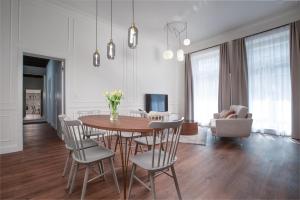 een eetkamer en een woonkamer met een tafel en stoelen bij OREA Place Seno in Praag