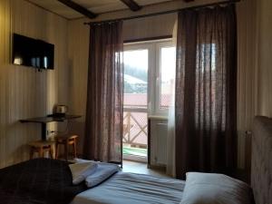 una camera d'albergo con un letto e una grande finestra di Guest House Mountain a Bukovel