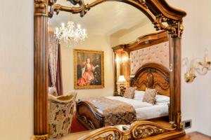 um quarto com uma cama de dossel e um espelho grande em Premier Prezident Garni Hotel and Spa em Sremski Karlovci