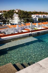 a pool of water with buildings in the background at Vitoria Stone Hotel in Évora