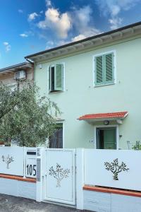 une maison blanche avec une clôture devant elle dans l'établissement B&B Ulivo Gaio, à San Miniato