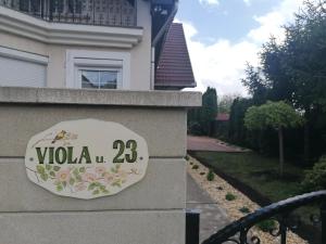 a sign on the side of a house at Viola Apartmanház in Bogács