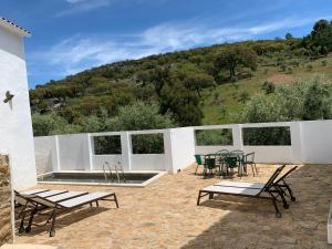 a patio with a table and chairs and a pool at Azeite de Marvão, Olivoturismo casa Venda do Lagar in Marvão