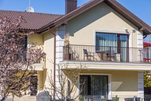 una casa con balcone e sedie di Sakura_INN Palanga a Palanga