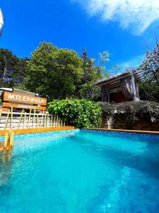 uma piscina com um banco ao lado de um edifício em Milennia Family Hotel em Sunny Beach