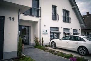 a white car parked in front of a building at Pension Yvonne - SUPERIOR in Rust