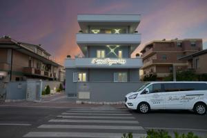 uma carrinha estacionada num parque de estacionamento em frente a um edifício em Rome Airport Inn em Fiumicino