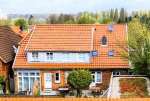 een huis met een oranje dak bij Kalkberg Ferienwohnungen in Bad Segeberg