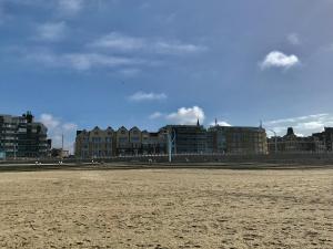 una spiaggia sabbiosa con edifici sullo sfondo di Sea view Scheveningen a Scheveningen