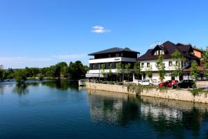 un edificio junto a un río al lado de un edificio en Holiday In Bihać, en Bihać