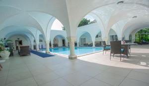 una piscina in un edificio con tavolo e sedie di Mzima Beach Residences - Diani Beach a Diani Beach