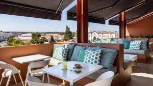 a patio with a couch and tables and chairs at Vitoria Stone Hotel in Évora