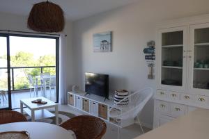 a living room with white furniture and a television at ROOF TOP SEA VIEW ALVOR in Alvor