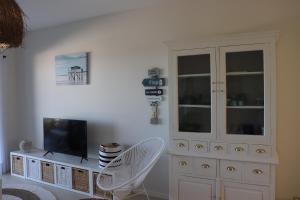 a living room with a tv and a white cabinet at ROOF TOP SEA VIEW ALVOR in Alvor