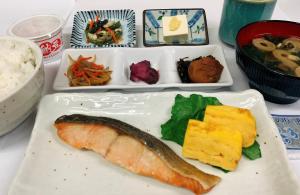 a plate of food with a piece of fish and other foods at Smile Hotel Nagoya Sakae in Nagoya