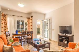 a living room with a couch and a tv at Vv Tirma in Caleta De Fuste