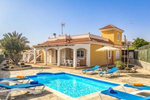 a villa with a swimming pool in front of a house at Vv Tirma in Caleta De Fuste