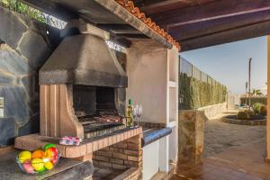 an outdoor oven with a bowl of fruit on a patio at Vv Tirma in Caleta De Fuste