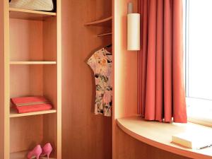 a closet with a red curtain and a shelf at ibis Southampton in Southampton