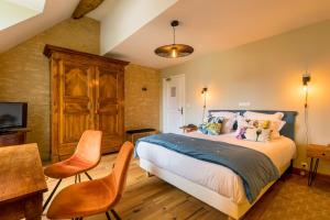 een slaapkamer met een bed en een tafel en stoelen bij Hôtel Le Clos in Montagny-lès-Beaune