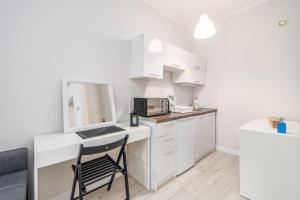 cocina pequeña con silla y microondas en Apartamenty Proeko Polonia, en Kołobrzeg