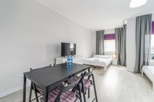 sala de estar con mesa negra y sillas en Apartamenty Proeko Polonia, en Kołobrzeg