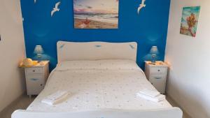 a bedroom with a bed with a blue wall and two night stands at A Casa di Margy in Ravello