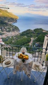 a table with a bowl of fruit on top of a balcony at A Casa di Margy in Ravello