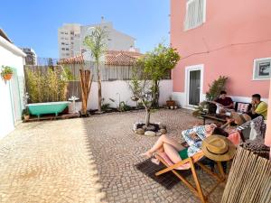 un groupe de personnes assises sur un patio dans l'établissement 4 Cantos, à Faro