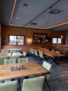 une salle à manger avec des tables et des chaises en bois dans l'établissement Herz3 Hotel Bar Restaurant Trattoria, à Hollersbach im Pinzgau