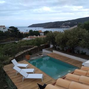 einen Pool mit 2 weißen Stühlen und Meerblick in der Unterkunft Casa Margot2 in Cadaqués