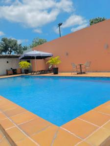 einen Pool mit einem Tisch und einem Sonnenschirm in der Unterkunft class hotel in Brazzaville