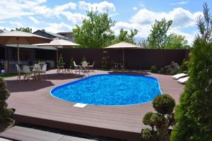 - une piscine dans une cour avec des chaises et des parasols dans l'établissement Pensiunea Casa Zece, à Turda