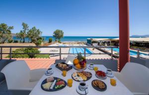 un tavolo con cibo sopra con vista sull'oceano di Giannarakis Beach a Stalós