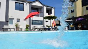 a pool with a red umbrella and a fountain at Le Thalassa Hôtel & Spa in Camaret-sur-Mer