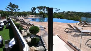 een zwembad met een terras en stoelen en een zwembad bij U Paesolu in Sainte-Lucie de Porto-Vecchio