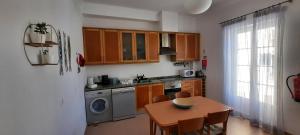 une cuisine avec des placards en bois et une table ainsi qu'une salle à manger dans l'établissement CasAzulApartments, à Sintra