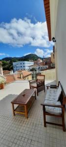 un patio avec des bancs et des tables dans un bâtiment dans l'établissement CasAzulApartments, à Sintra