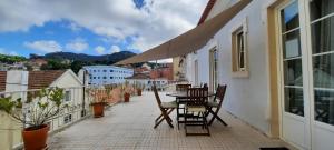 d'une terrasse avec une table et des chaises sur un balcon. dans l'établissement CasAzulApartments, à Sintra