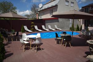 d'une terrasse avec des tables et des chaises à côté de la piscine. dans l'établissement Pensiunea Casa Zece, à Turda