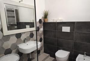 bagno con lavandino, servizi igienici e specchio di NEW HOME - appartamento in centro storico a Cagliari