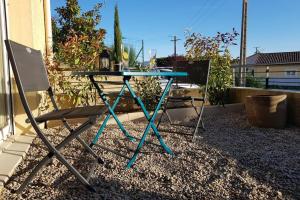 una mesa azul y una silla en el patio en Cocon chic au pied du Vercors avec parking, en Marches