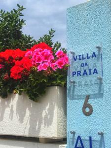 un panneau indiquant la villa da praia à côté des fleurs dans l'établissement Villa da Praia, à Sintra