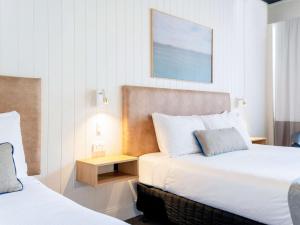 ein Hotelzimmer mit 2 Betten und einem Tisch in der Unterkunft Mercure Charlestown in Newcastle