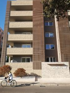 uma pessoa a andar de bicicleta em frente a um edifício em Istai Poetto Apartment em Cagliari