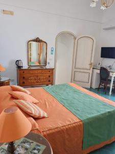 Schlafzimmer mit einem Bett, einer Kommode und einem Spiegel in der Unterkunft Casa Teresa in Positano