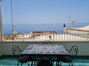 einen Tisch und Stühle auf dem Balkon eines Kreuzfahrtschiffes in der Unterkunft Casa Teresa in Positano