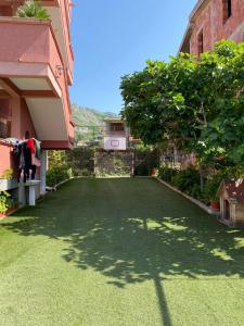 un patio con césped verde frente a un edificio en Apartments Nikičić, en Bar